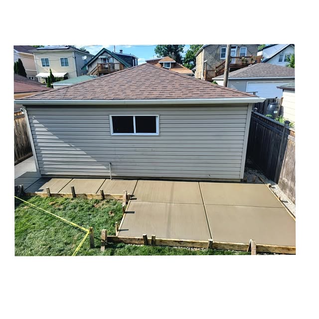 Fresh concrete driveway and parking pad behind residential garage