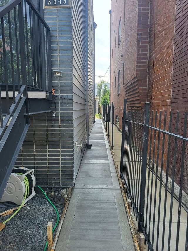 Fresh concrete sidewalk replacement between buildings